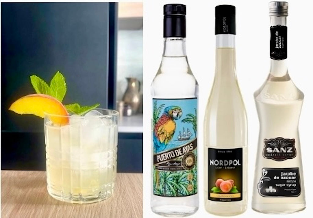 Caribbean Peach Cocktail mit Eis, Pfirsichscheibe und Minze, daneben Rum, Pfirsichlikör und Zuckersirup als Hauptzutaten.