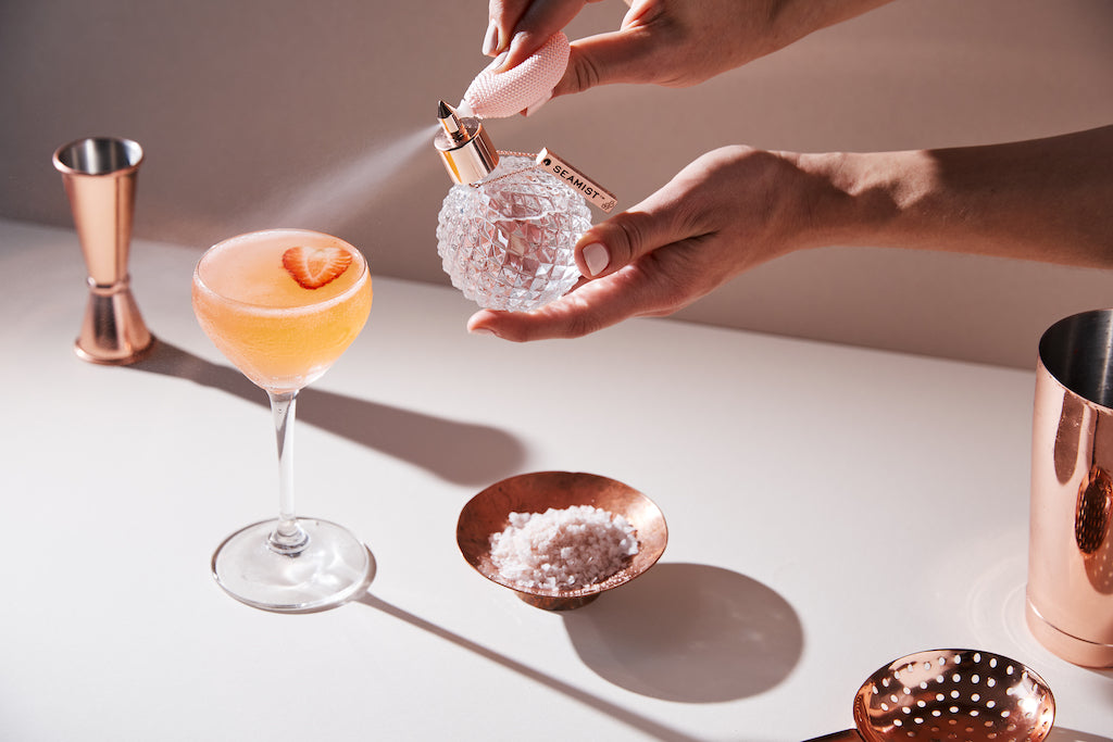 Ein frischer Cocktail mit Seamist Liquid Garnish, stilvoll serviert mit Kupferbarzubehör und einer eleganten Dekoration.