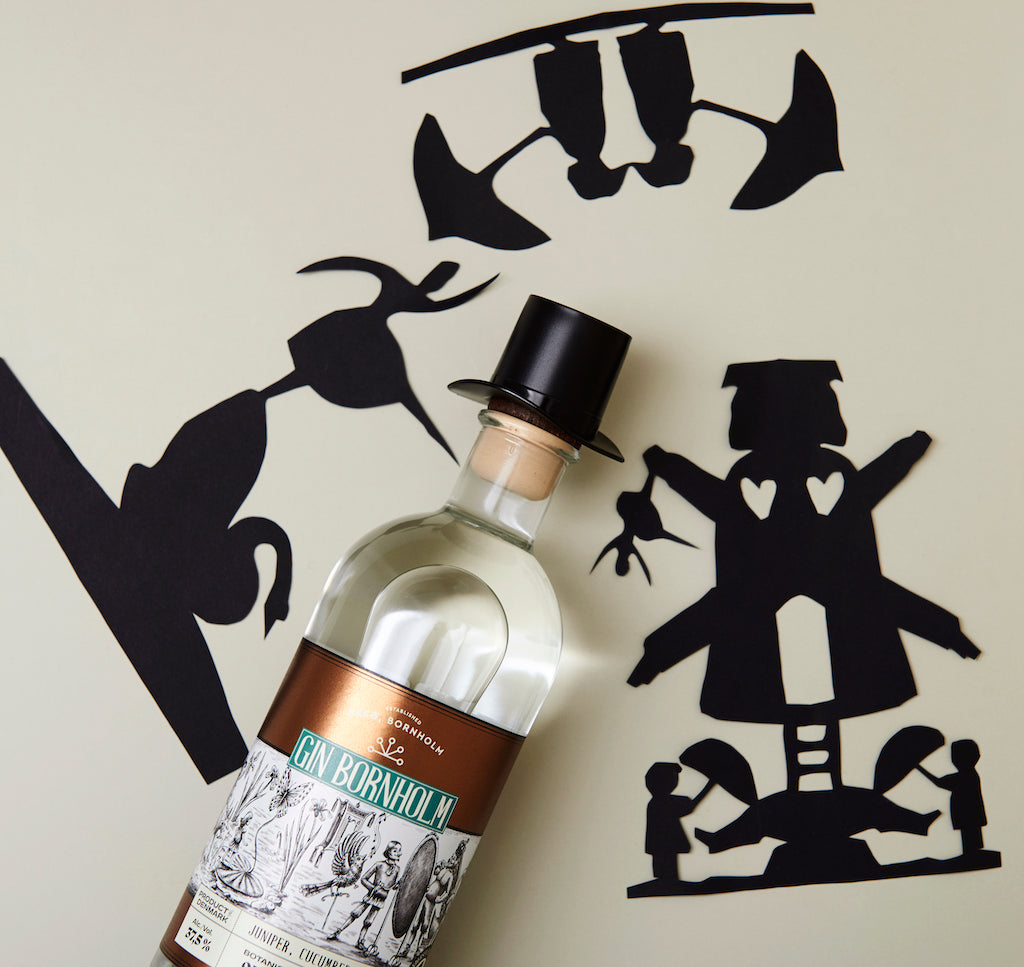 Bio Gin Bornholm, Flasche mit Zylinder und Holzverschluss, umgeben von schwarzen Märchen-Silhouetten auf hellem Hintergrund.