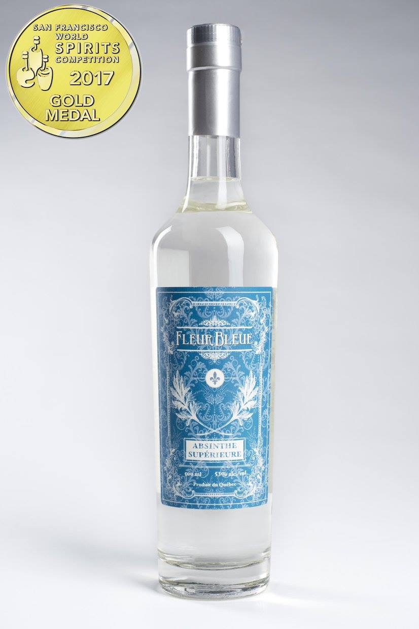 Fleur Bleue Absinth Flasche mit blauem Etikett und Goldmedaille 2017 auf grauem Hintergrund
