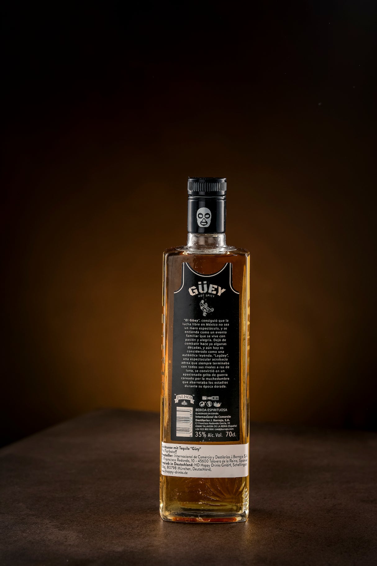 Die Rückseite der Güey Tequila Gold Flasche mit detaillierter Produktbeschreibung und Herstellerangaben, präsentiert auf dunklem Hintergrund.