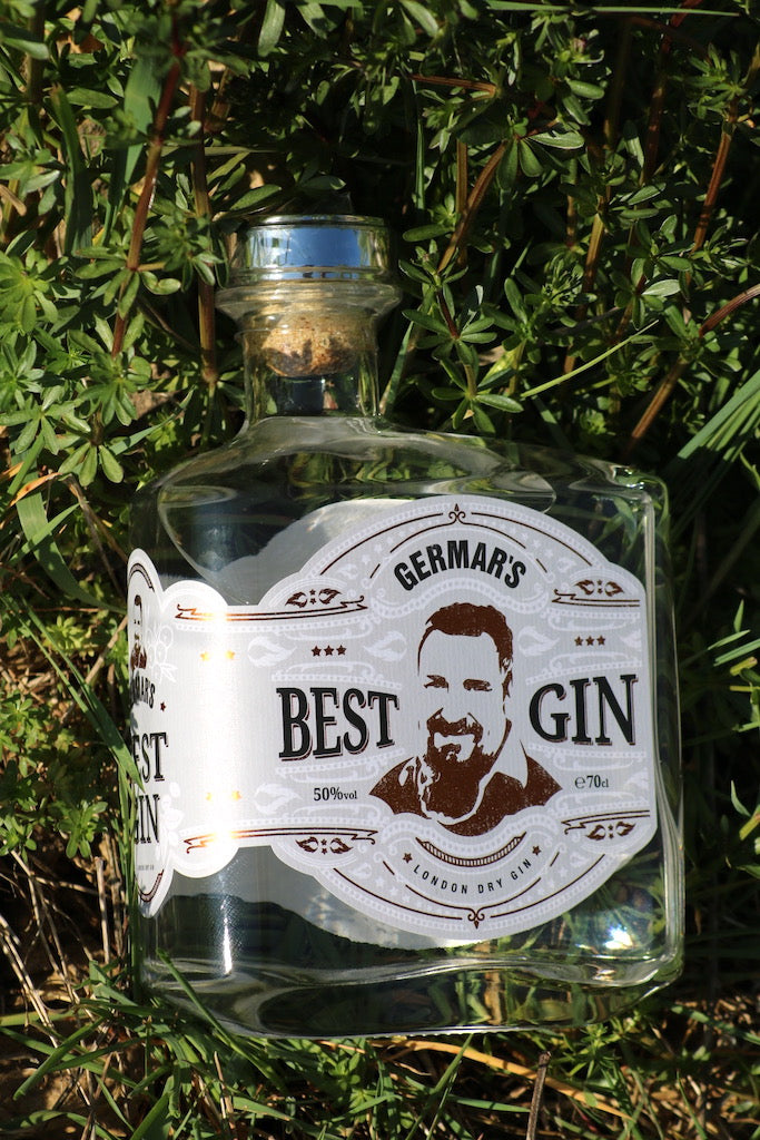 Germar's Best Gin, London Dry Gin, Flasche im Grünen liegend, umgeben von frischem Frühlingslaub und natürlicher Vegetation.
