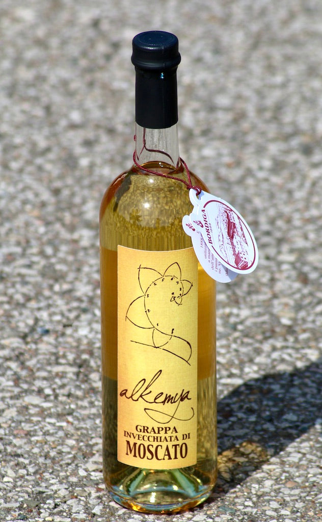 Flasche Grappa Invecchiata di Moscato Alkemya von Bordiga, goldene Farbe, mit schwarzem Verschluss und Etikett.