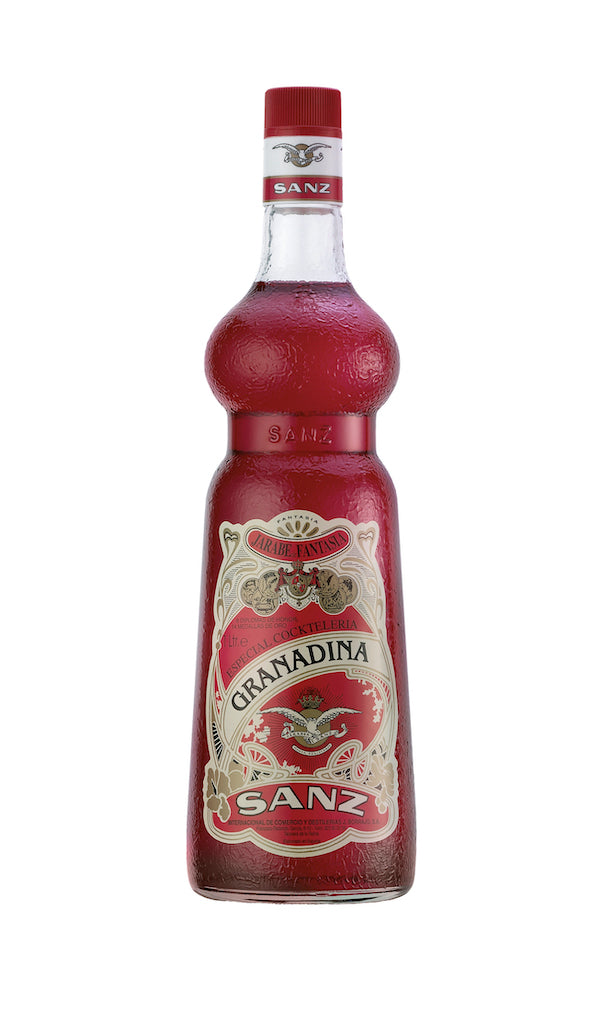 Flasche Grenadine von SANZ mit roter Flüssigkeit und verziertem Etikett auf weißem Hintergrund