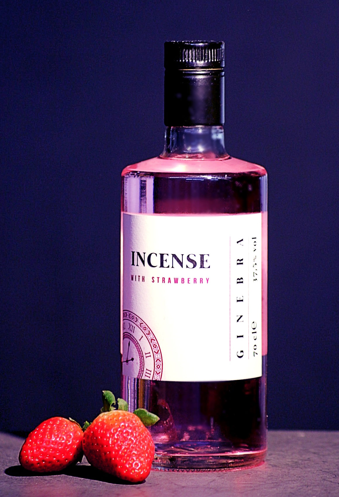 Flasche Incense Gin mit Erdbeergeschmack, rosa Flüssigkeit, vor dunklem Hintergrund, dekoriert mit zwei frischen Erdbeeren.
