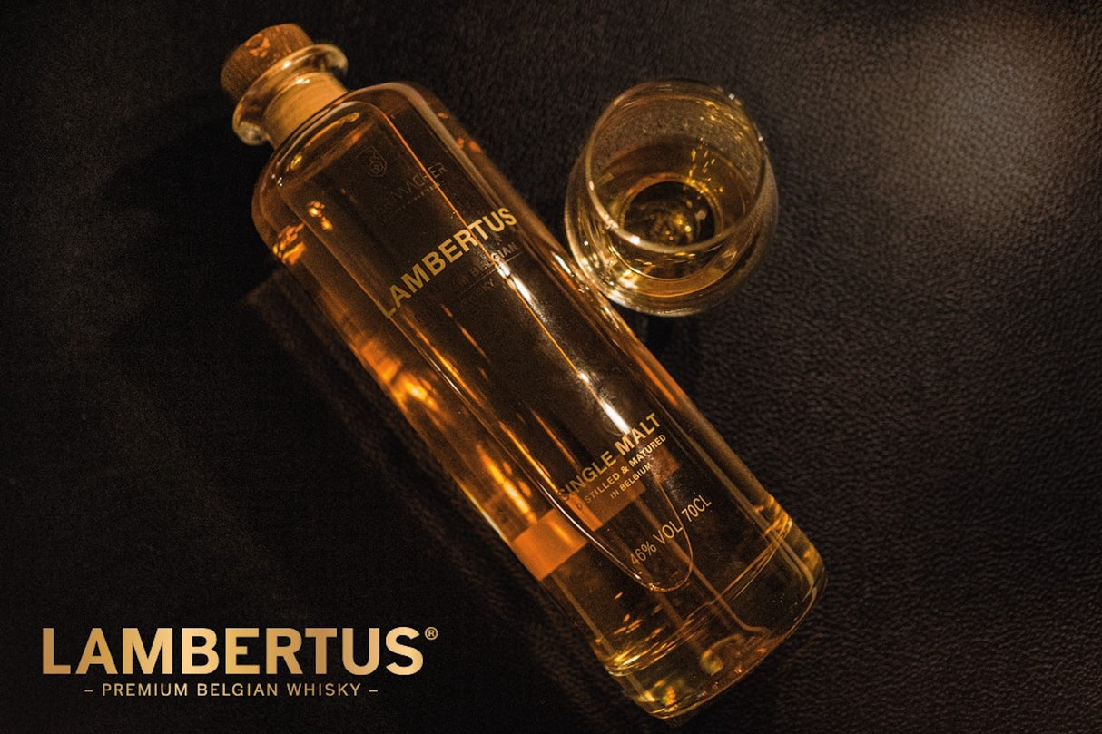 Lambertus Single Malt Whiskyflasche mit passendem Tumbler-Glas auf dunkler Oberfläche, goldene Reflexe im Licht