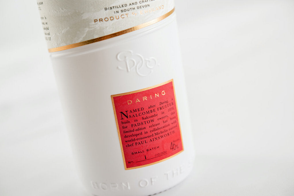 Detailaufnahme des roten Etiketts von Salcombe Gin Daring, Limited Edition, mit Informationen zur Zusammenarbeit und Batch-Nummer.