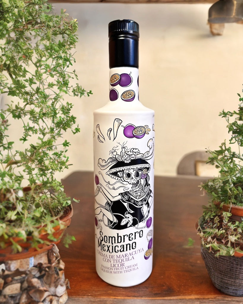 Flasche Sombrero Mexicano Maracuja-Tequila-Likör mit Totenkopf-Design, lila Passionsfrucht-Dekor, arrangiert zwischen Pflanzen.