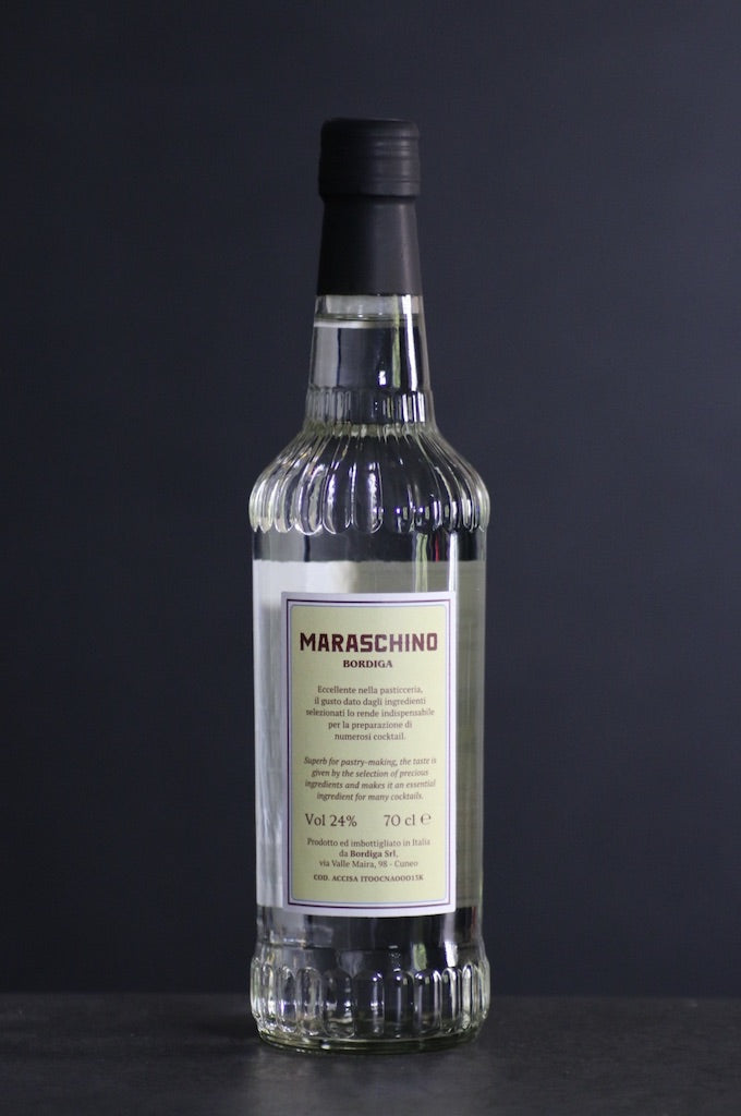 Rückseite der Maraschino Likörflasche von Bordiga mit Zutatenhinweis und Alkoholgehalt vor dunklem Hintergrund.