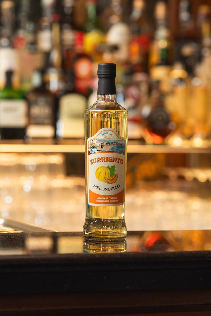 Flasche Surriento Meloncello auf einer Bartheke, unscharfe Flaschen im Hintergrund.