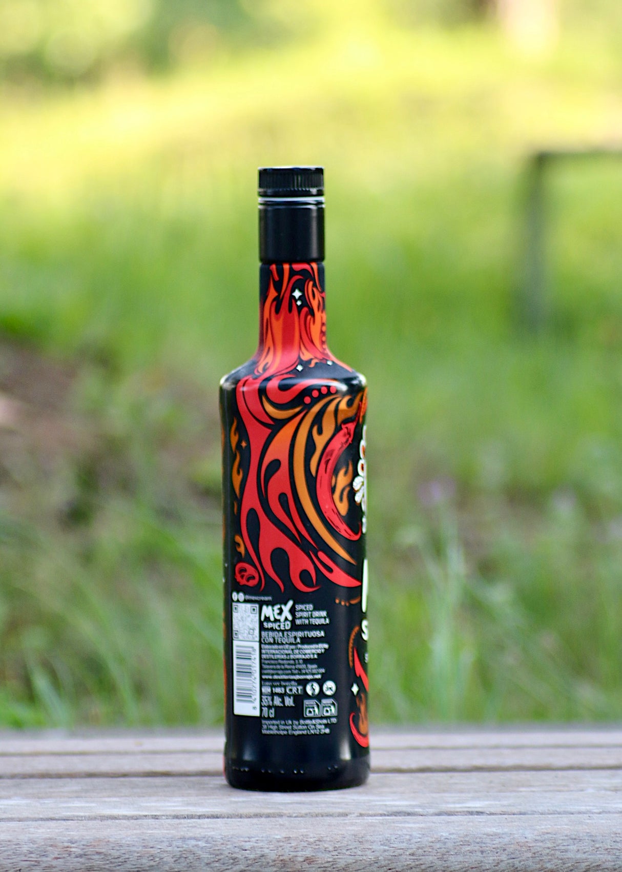 Rückseite der Mex Spiced Tequila Spirituose mit Chili, feuriges Flaschendesign in Rot-, Orange- und Schwarztönen.