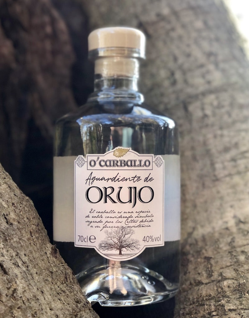 O’Carballo Orujo Flasche zwischen Baumrinde, klarer spanischer Tresterschnaps mit weißem Etikett, 70 cl, 40 % vol.
