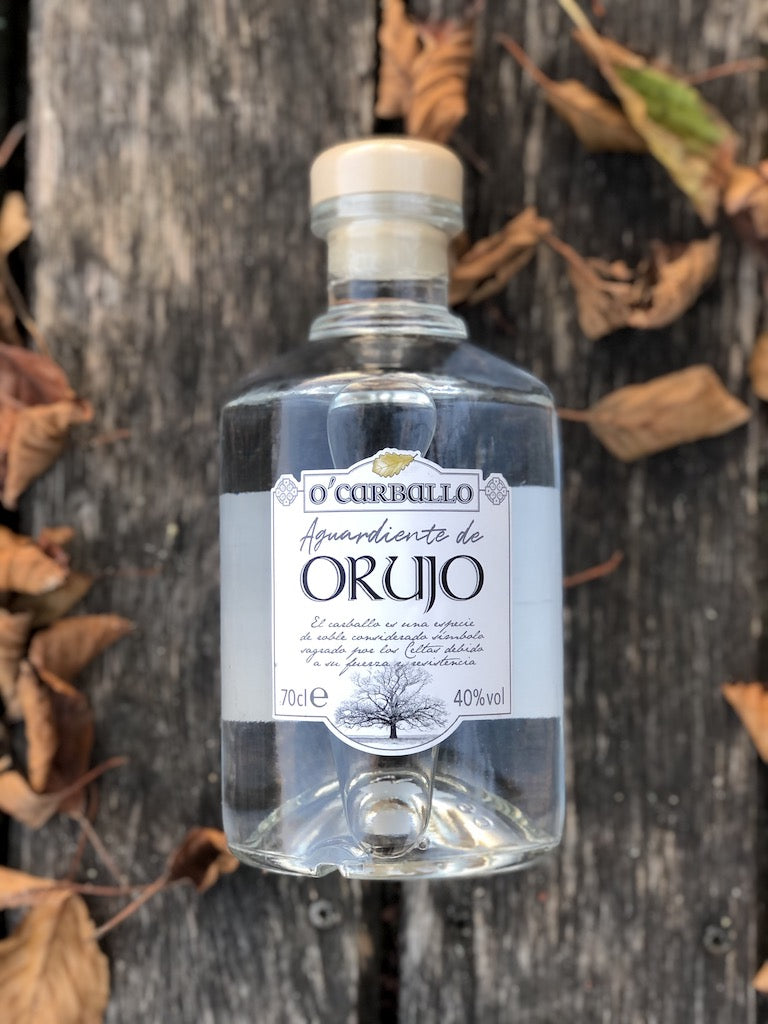 O’Carballo Orujo Flasche auf Holz mit herbstlichen Blättern, klarer spanischer Tresterschnaps, 70 cl, 40 % vol.