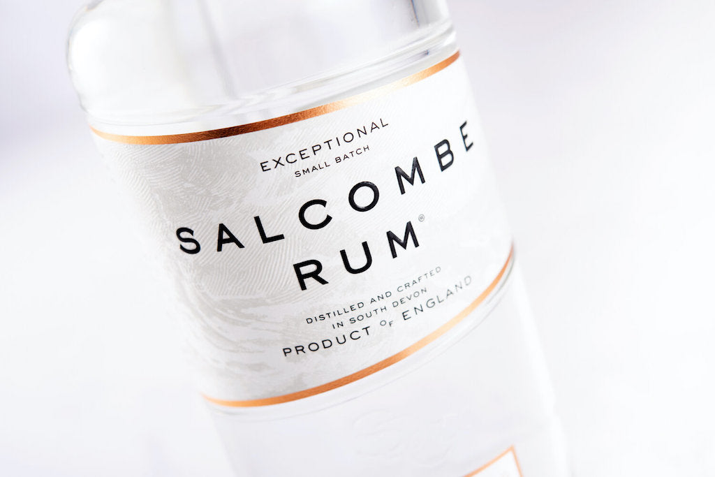 Nahaufnahme des Etiketts einer Salcombe Spiced White Rum Flasche mit edlem, weiß-goldenem Design und feiner Beschriftung.