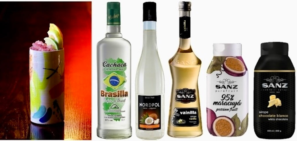 Samba-Cocktail mit Crushed Ice und Zitrusdeko im bunten Becher, daneben Flaschen mit den Zutaten des Sets.