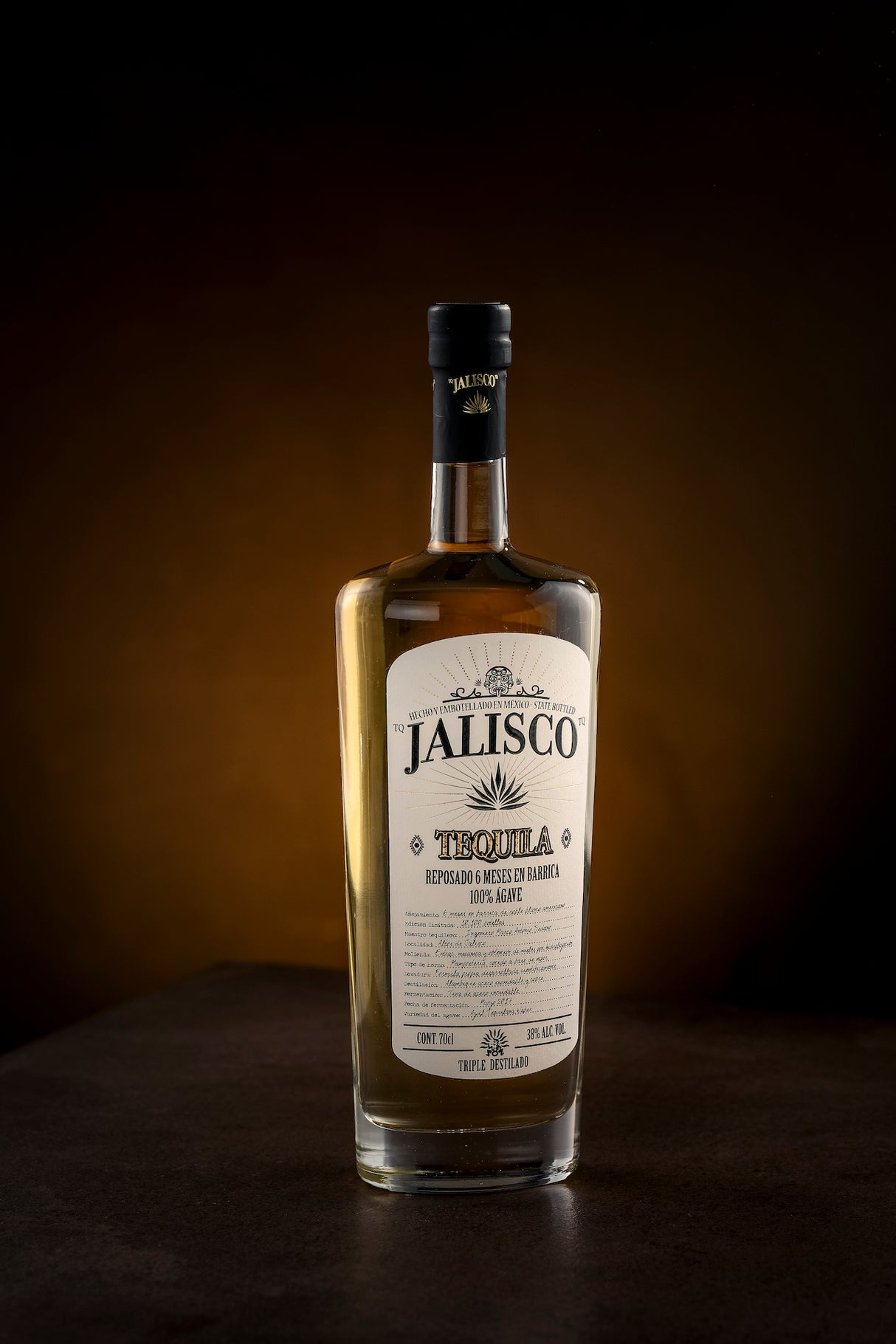 Tequila Jalisco Reposado Flasche, 100% Agave, auf dunklem Hintergrund stilvoll präsentiert.