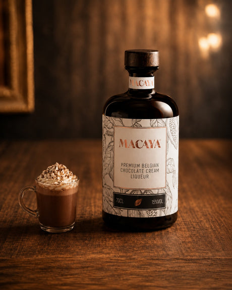 Macaya Schokoladenlikör Flasche mit kleinem Schoko Kaffee Getränk auf Holztisch vor warmem Hintergrund