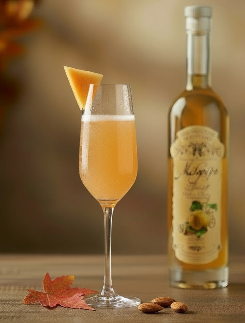 Melo Spritz Cocktail im Flöten-Glas mit Melonenstück, daneben Mélopépo Melonen-Mandeln-Likör Flasche.