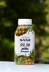 Flasche Ananas-Püree von Sanz mit 99,9% Piña. Die Flasche zeigt eine Abbildung von Ananas, im Hintergrund verschwommene Natur. Hergestellt in Spanien.