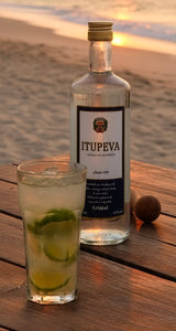 lasche Cachaça Itupeva Cristal und Glas Caipirinha auf Holztisch am Strand bei Sonnenuntergang
