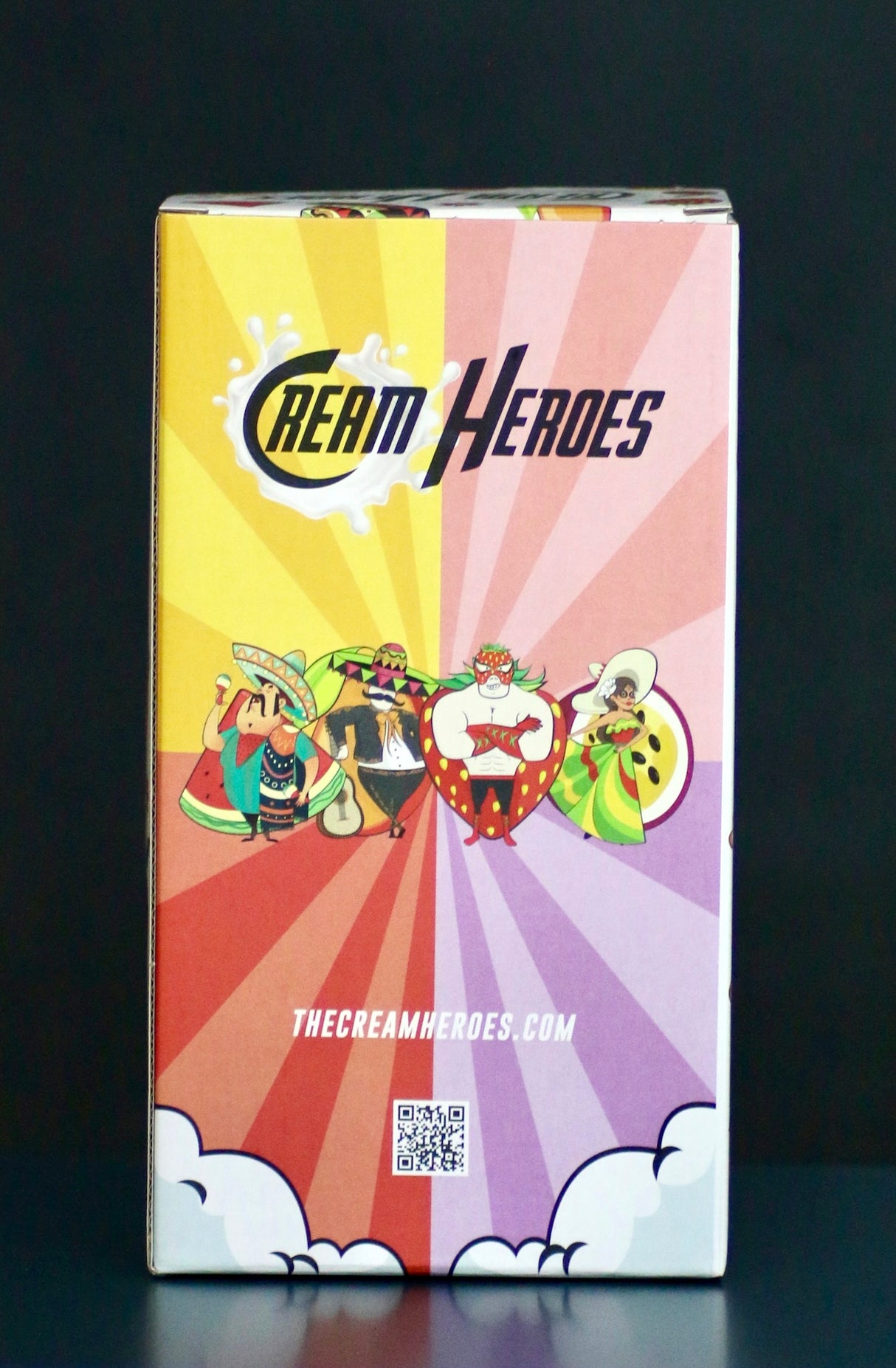 Rückseite der Cream Heroes Likör Geschenkbox mit buntem Design, Comicfiguren und dem Schriftzug "Cream Heroes" sowie QR-Code.