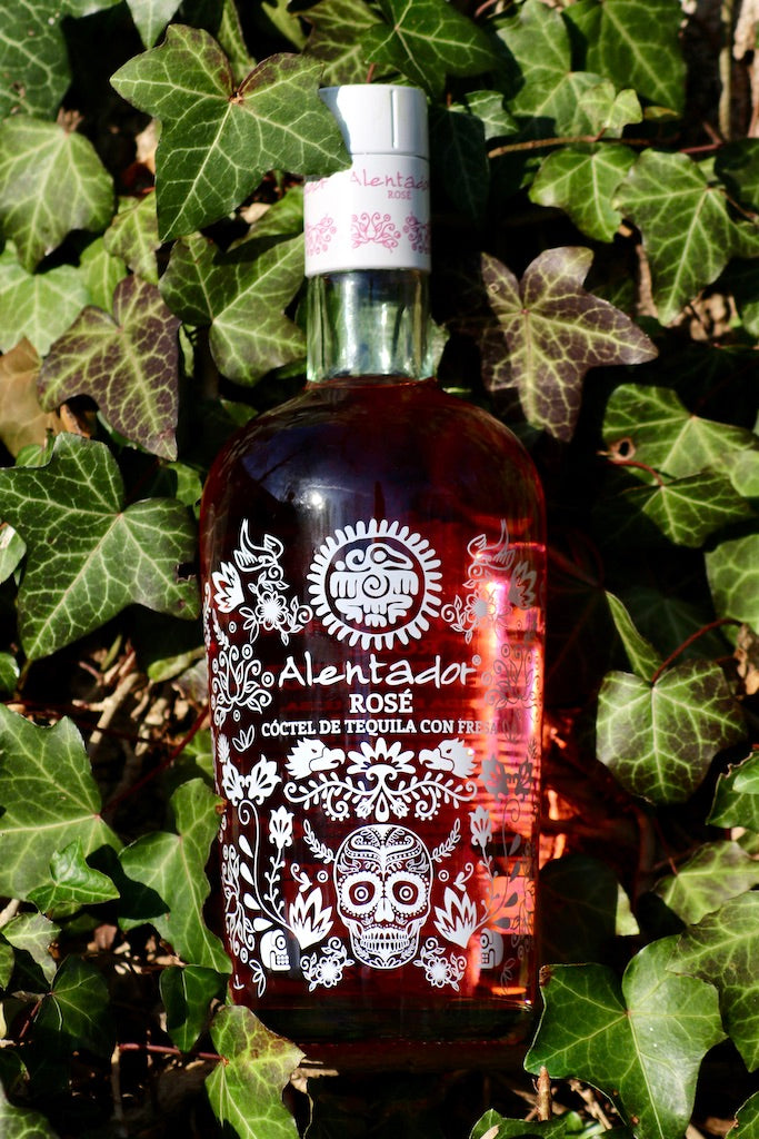 Flasche Alentador Rosé Tequila Cocktail mit Erdbeere auf Efeu