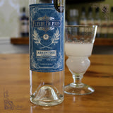 Fleur Bleue Absinth Flasche neben milchigem Absinthglas auf Holzbar