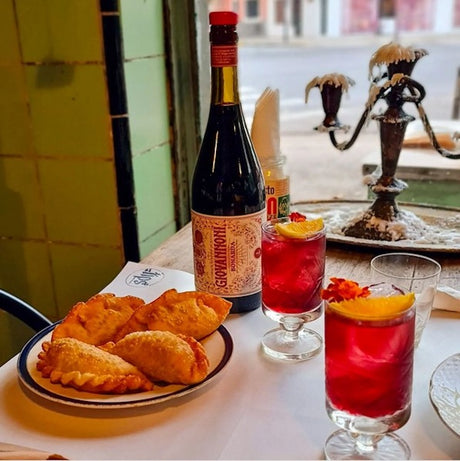 Giovannoni Rosso Flasche mit Gläsern in Restaurant mit Empanadas