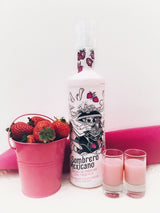 Flasche Sombrero Mexicano Erdbeer-Tequila-Likör, umgeben von einem pinken Eimer voller frischer Erdbeeren und zwei Gläsern mit rosa Likör, stilvoll arrangiert vor einem weißen Hintergrund mit pinken Akzenten.