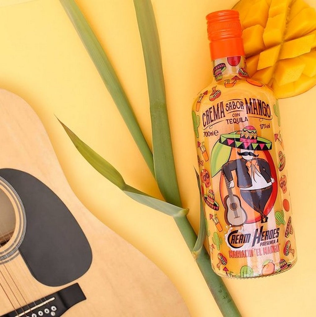 Mariachi El Mango Tequila-Likörflasche auf gelbem Hintergrund mit einer Gitarre und Mango-Stückchen, dekoriert mit einer grünen Pflanze.