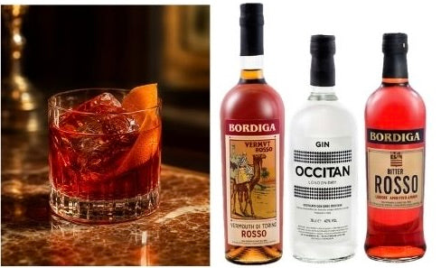 Negroni im Glas mit Orangenzeste neben Bordiga Vermouth Rosso, Occitan Gin und Bitter Rosso Flasche