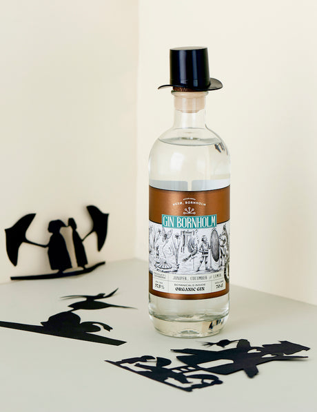 Bio Gin Bornholm, stilvolle Flasche mit Zylinder, schwarze Silhouetten-Dekoration, Aromen von Gurke und Zitrone.