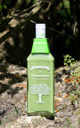 Pechery Pistazios Cream Liqueur in hellgrüner Flasche mit Baumdesign auf Felsen in der Natur
