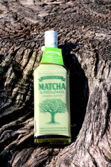 Pechery Matcha & Pistachios Cream Liqueur Flasche auf Baumrinde mit grünem Halsetikett