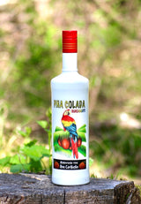 Flasche Guacamayo Piña Colada mit farbenfrohem Papagei-Design, stehend auf einem Baumstumpf, hergestellt mit karibischem Rum.