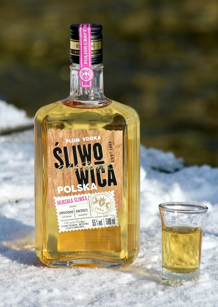 Sliwowitza Polska Pflaumen-Schnaps mit Glas auf Schnee