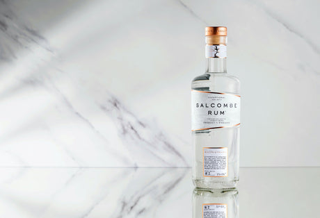 Flasche Salcombe Spiced White Rum Whitestrand, 50 cl, 42,4 % vol., präsentiert auf einer glatten Marmoroberfläche, Produkt aus England.