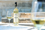 Château de St Martin Grande Réserve Blanc Weißwein mit Glas auf Tisch vor Steinmauer und Treppe