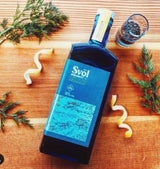 Svöl Aquavit schwedisch-Style liegend auf Tisch mit frischen Botanicals