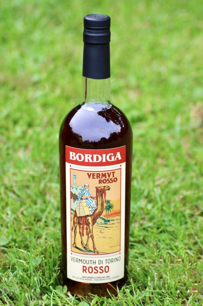 Flasche Bordiga Vermouth di Torino Rosso mit traditionellem Etikett, stehend auf einer grünen Rasenfläche.