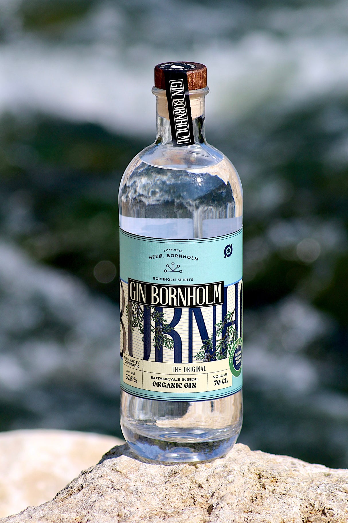 Flasche Bio Gin Bornholm auf einem Felsen vor natürlichem Hintergrund.